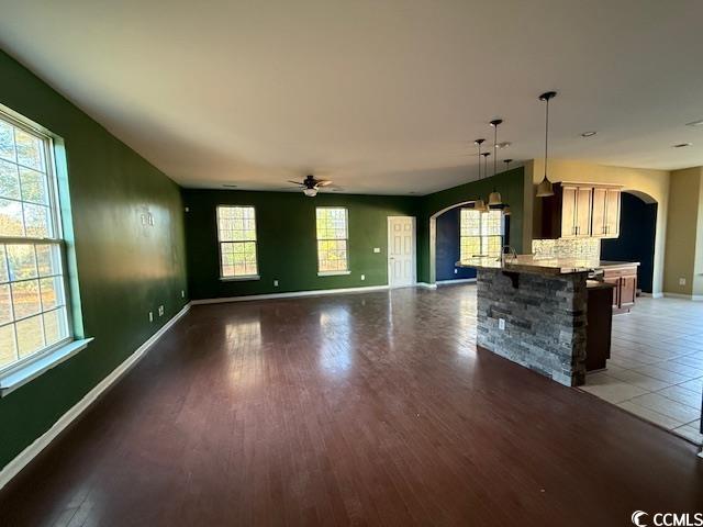 237 Golden Oaks Drive Murrells Inlet, SC 29576 - Photo 15 of 21 Unfurnished living room featuring arched walkways, a ceiling fan, and dark wood-type flooring