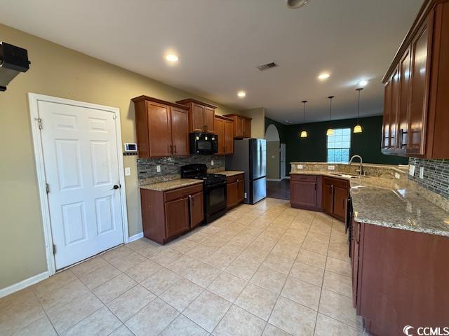 237 Golden Oaks Drive Murrells Inlet, SC 29576 - Photo 18 of 21 Kitchen with backsplash, light stone countertops, black appliances, arched walkways, and decorative light fixtures