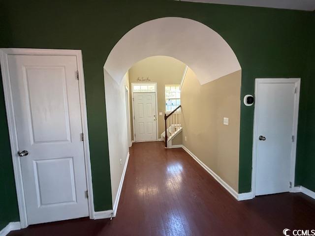 237 Golden Oaks Drive Murrells Inlet, SC 29576 - Photo 7 of 21 Hallway featuring dark wood-style flooring, arched walkways, and vaulted ceiling