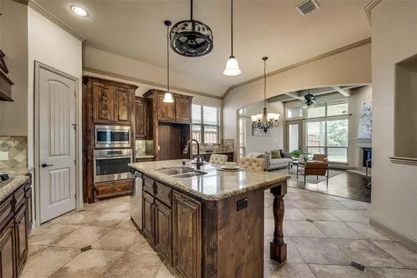 a kitchen with a stove a sink a dining table and chairs