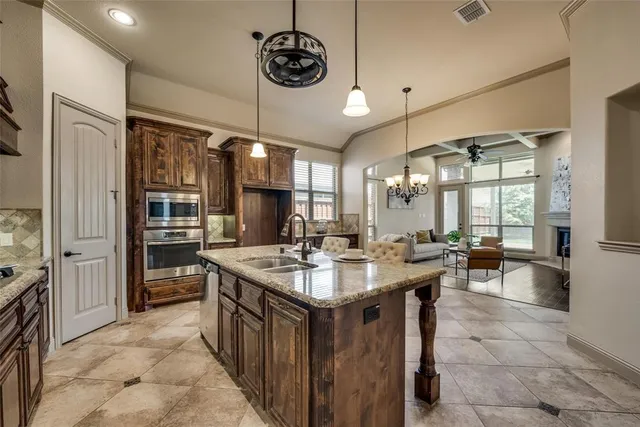 a kitchen with a stove a sink a dining table and chairs