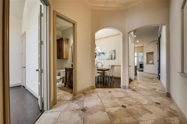 a bedroom with a large bed chandelier and a window