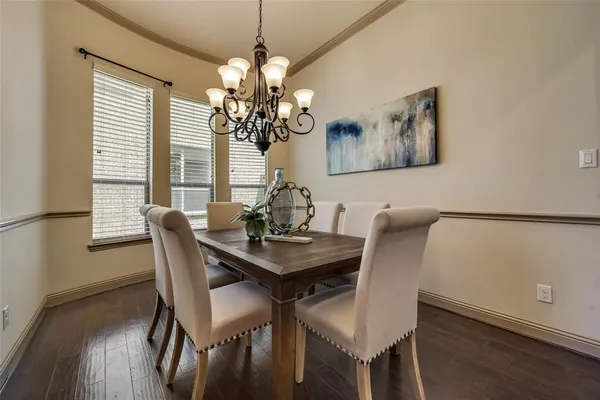 a view of a dining room with furniture a chandelier and wooden floor