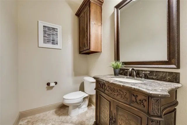 a bathroom with a granite countertop toilet a sink and a mirror