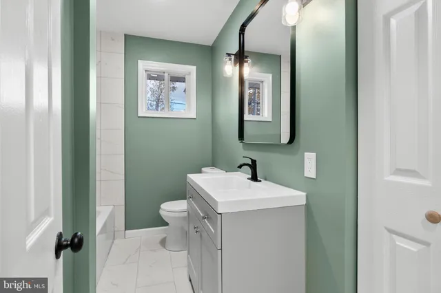 a bathroom with a toilet sink and mirror