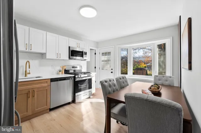a large white kitchen with cabinets a sink and a stove