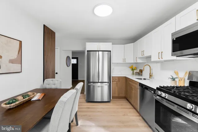 a kitchen with granite countertop a refrigerator stove top oven and sink