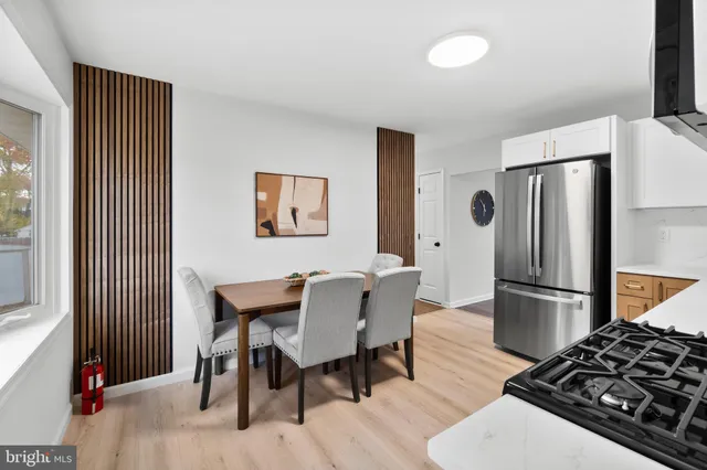 a kitchen with stainless steel appliances granite countertop a stove a refrigerator and a dining table