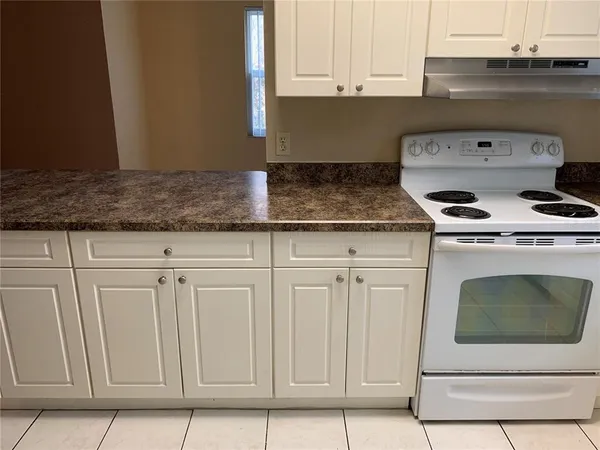 a kitchen with granite countertop white cabinets and white appliances