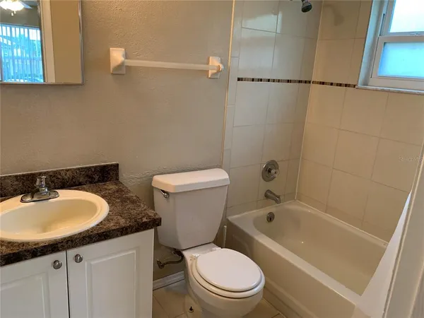a white toilet sitting next to a bath tub