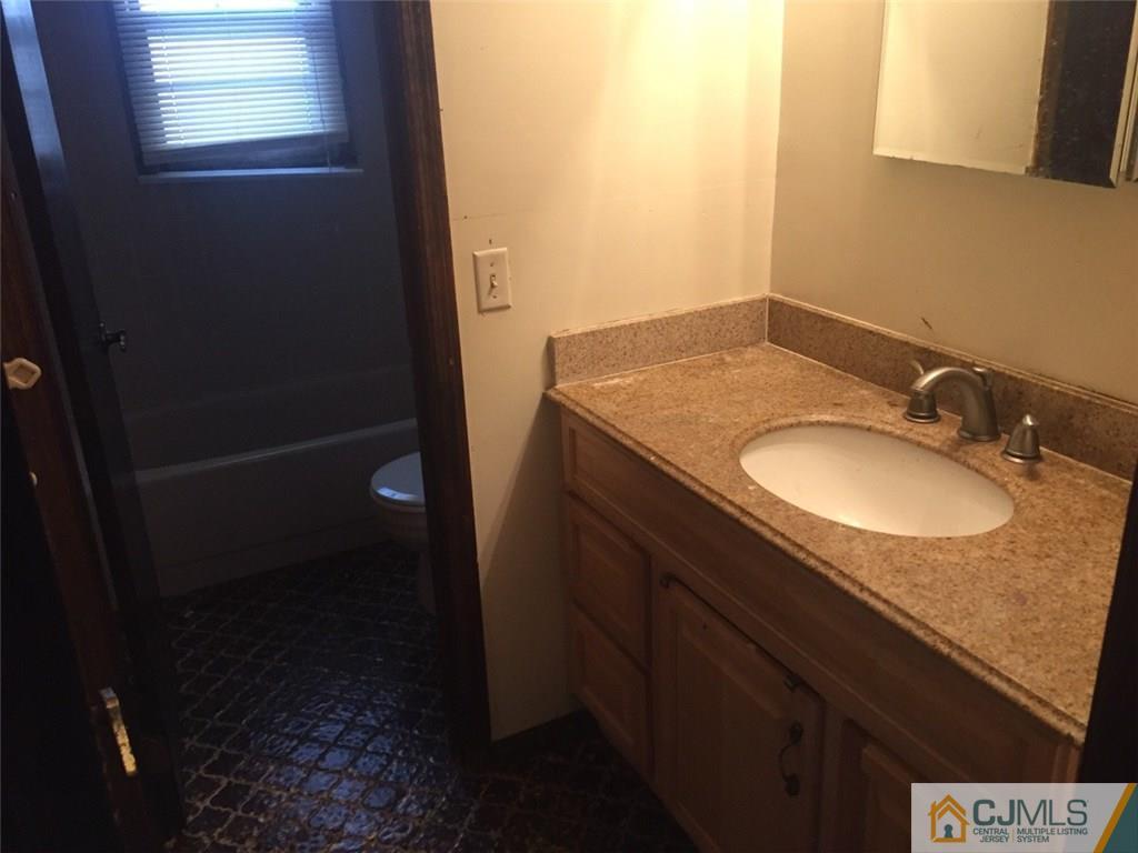 29 Roxy Avenue Edison, NJ 08820 - Photo 8 of 11 a bathroom with a granite countertop sink and a mirror