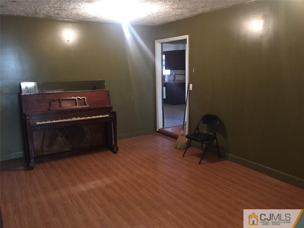 29 Roxy Avenue Edison, NJ 08820 - Photo 10 of 11 a room with a piano and wooden floor