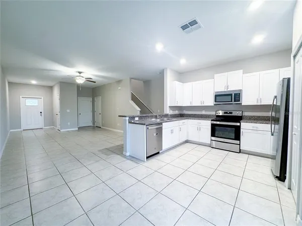 a kitchen with stainless steel appliances granite countertop a stove a sink and a refrigerator