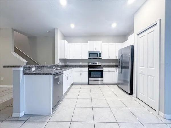a large kitchen with a stove a refrigerator and a sink
