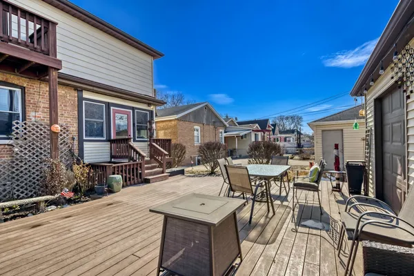 a view of a patio with table and chairs and wooden floor