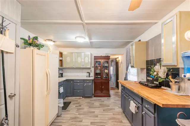 a large kitchen with stainless steel appliances kitchen island granite countertop a refrigerator and a sink