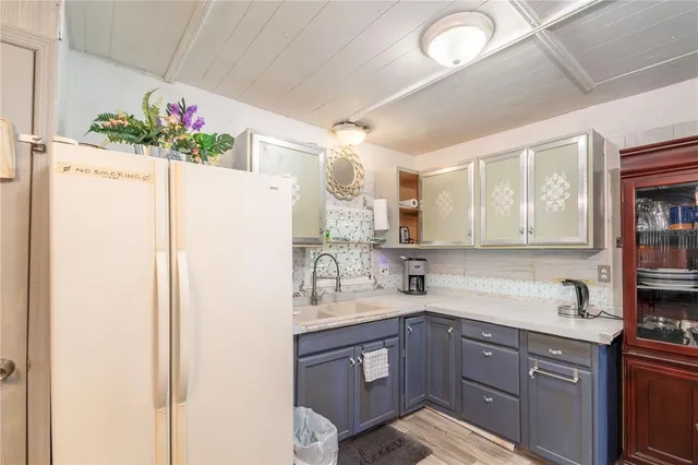 a kitchen with a refrigerator sink and white cabinets