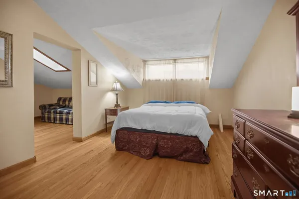 a bedroom with a large bed and wooden floor