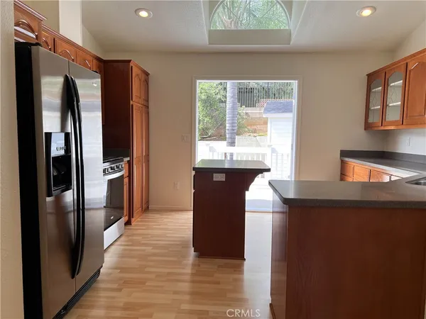 a kitchen with stainless steel appliances granite countertop a refrigerator a sink and a stove