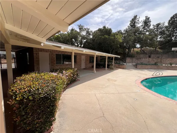 a view of a house with backyard and sitting area