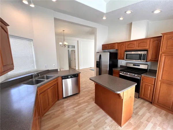 a kitchen with stainless steel appliances granite countertop a stove a sink and a refrigerator