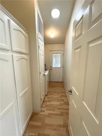 a view of a hallway with wooden floor and closet