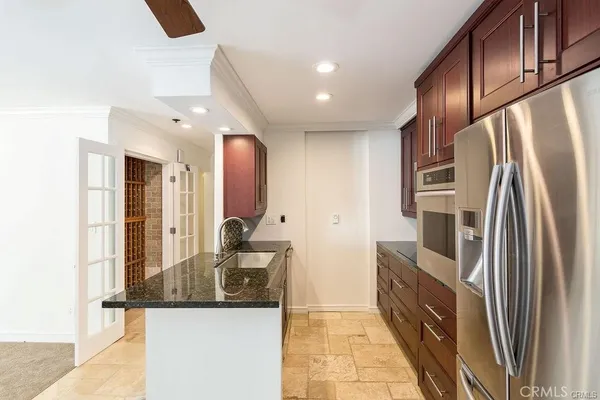 a kitchen with stainless steel appliances granite countertop a refrigerator and a sink