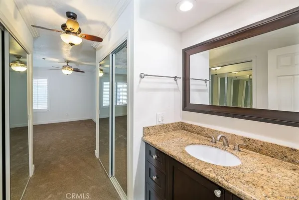 a bathroom with a granite countertop sink a light fixture and a mirror