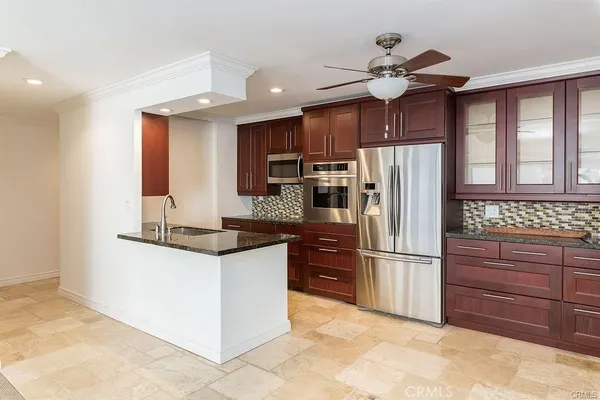 a kitchen with granite countertop a refrigerator and a stove top oven