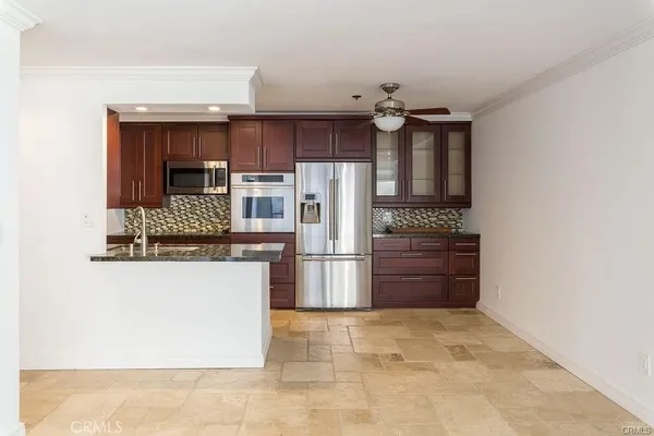 a kitchen with granite countertop a refrigerator and a stove