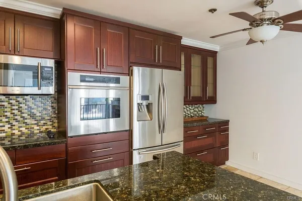 a kitchen with granite countertop wooden cabinets and refrigerator