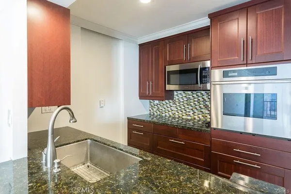 a kitchen with granite countertop wooden cabinets and granite counter tops