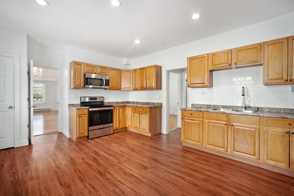 40 Orchard Street Chicopee, MA 01013 - Photo 11 of 34 a kitchen with granite countertop wooden floors stainless steel appliances and sink