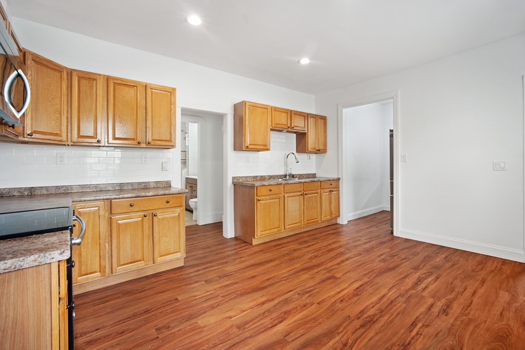 40 Orchard Street Chicopee, MA 01013 - Photo 13 of 34 a kitchen with granite countertop wooden floors and stainless steel appliances