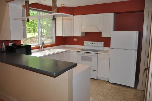 a kitchen with a white cabinets and white appliances