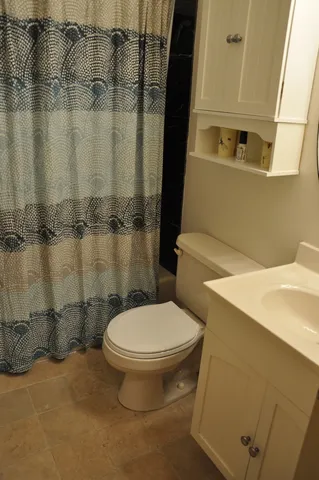 a white toilet sitting next to a bathroom sink