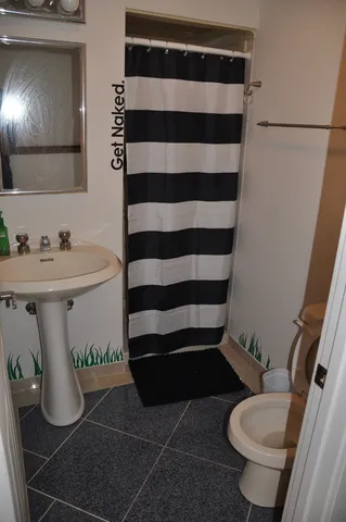 a bathroom with a sink toilet and shower