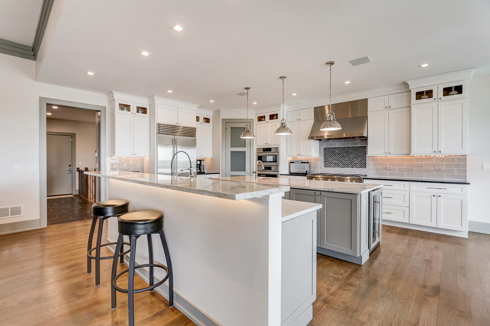 1812 Hunters Ridge Lane Sugar Grove, IL 60554 - Photo 9 of 45 a kitchen with stainless steel appliances kitchen island granite countertop a stove a sink a refrigerator and white cabinets with wooden floor