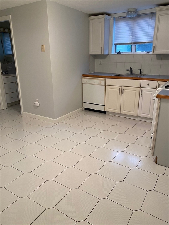 1 Salem Street, Unit B1 Wakefield, MA 01880 - Photo 8 of 12 a kitchen with granite countertop white cabinets and a sink
