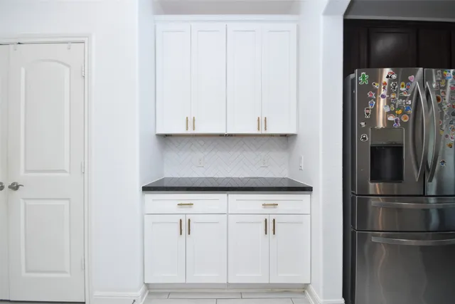 a large kitchen with stainless steel appliances a large counter top and a stove top oven