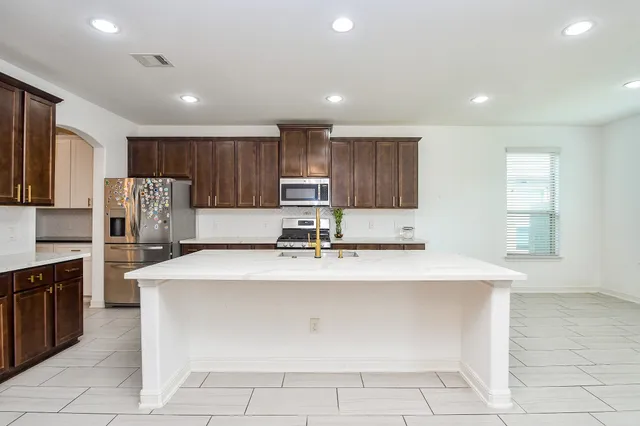 a open kitchen with kitchen island a sink dishwasher and a fireplace with wooden floor
