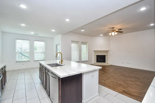 a kitchen with stainless steel appliances granite countertop a sink a stove and a wooden cabinets