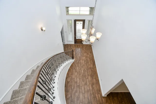 an empty room with chandelier fan and ceiling fan
