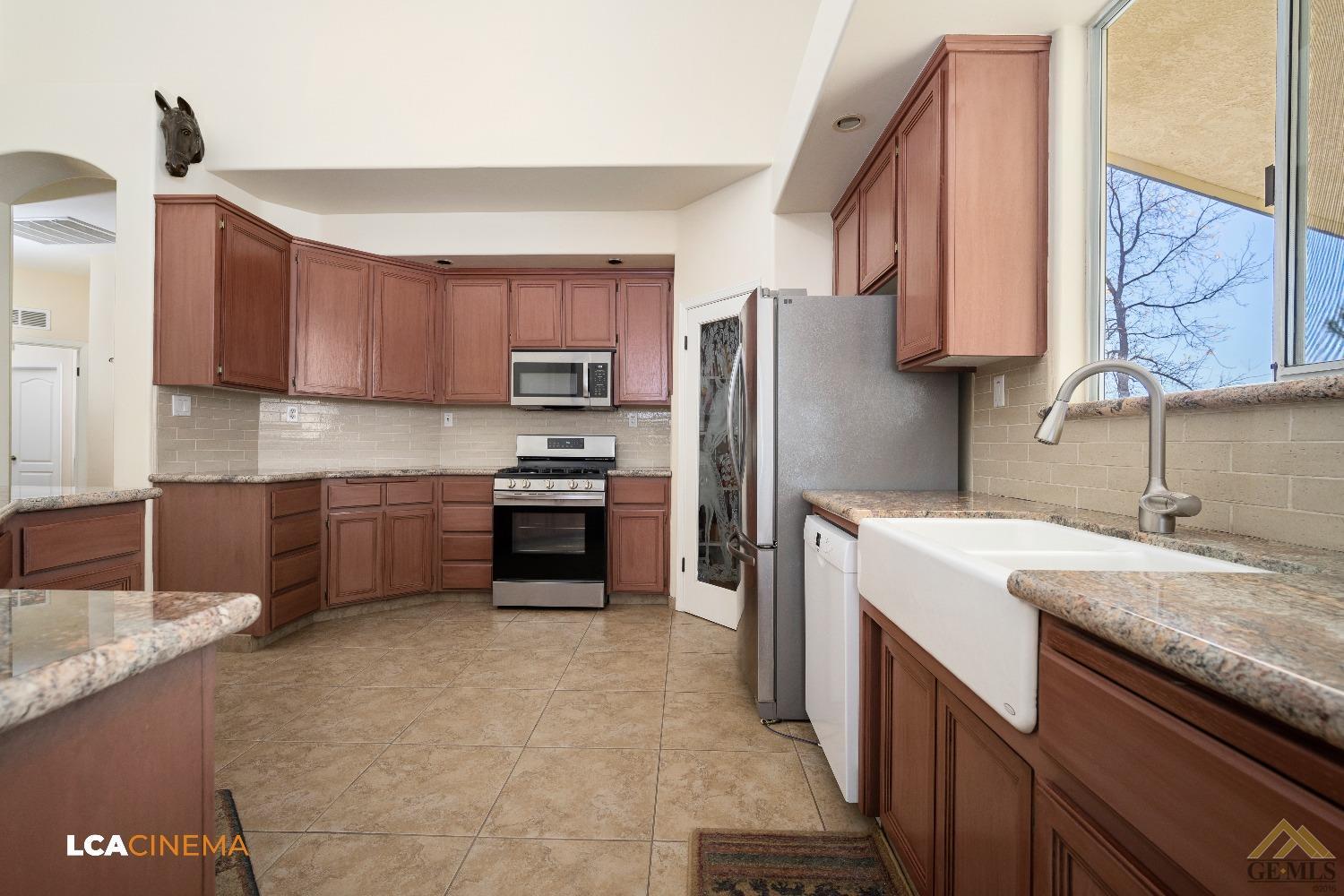 Undisclosed Address Bakersfield, CA 93314 - Photo 8 of 33 a kitchen with a sink a stove and a refrigerator