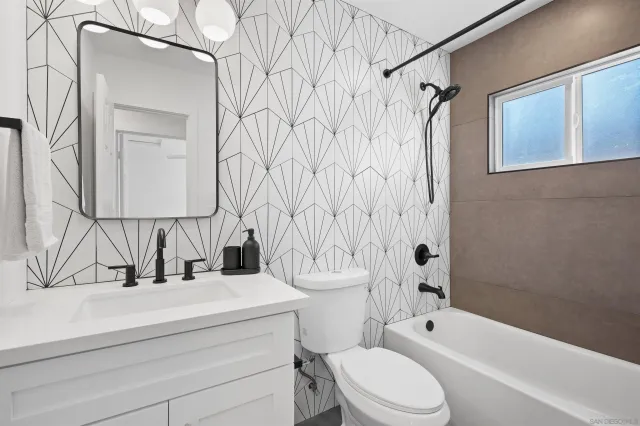 a bathroom with a granite countertop sink toilet a mirror and shower