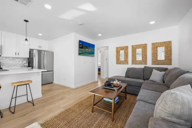 a living room with furniture and a kitchen view