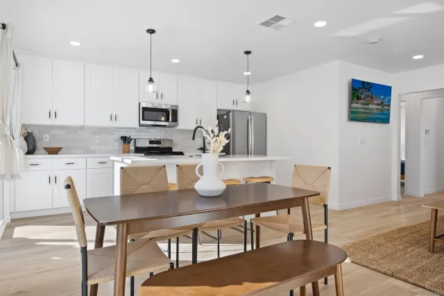 a kitchen with kitchen island a dining table and chairs