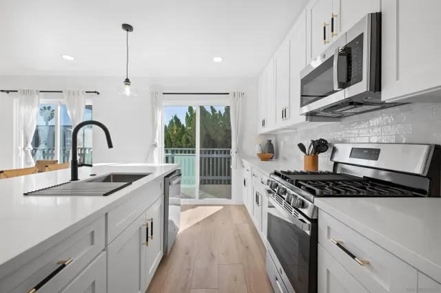 a kitchen with stainless steel appliances a sink stove and cabinets