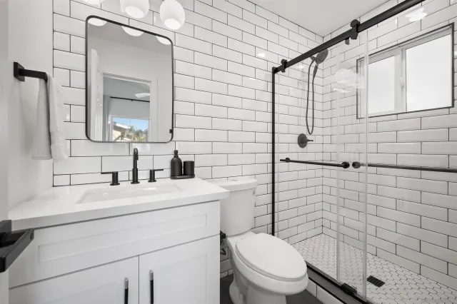 a bathroom with a toilet sink vanity and mirror