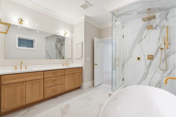 a spacious bathroom with a tub sink shower and mirror